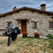 BMW R1250 GS Adventure in front of a rustic house in Italy
