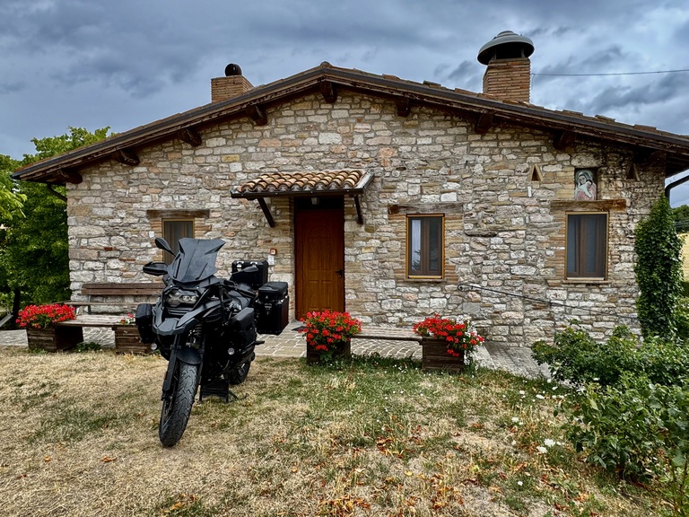 BMW R1250 GS Adventure in front of a rustic house in Italy