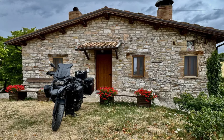 BMW R1250 GS Adventure in front of a rustic house in Italy